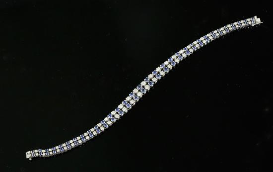 A 20th century 14ct white gold, graduated sapphire and diamond twin line bracelet, 18cm.